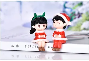 Macro view of Christmas couple miniature figurines sitting on a decorative platform
