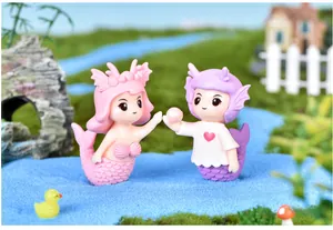 Miniature mermaid couple figurines set in a colorful micro landscape garden