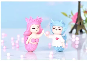 Detailed close-up of cute pink and blue mermaid couple figurines for micro landscape decor
