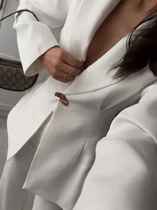 Elegant white waist-cinching blazer with peaked lapels and gold-tone decorative button
