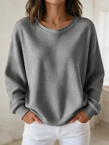 Close-up of a women's grey round neck waffle knit long sleeve casual sweatshirt
