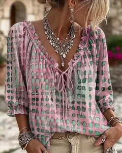 Detalle de la blusa de estampado étnico rosa y verde con escote de volantes y lazo.