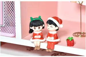Macro detail of cute sitting Christmas couple figurines in festive red and white outfits