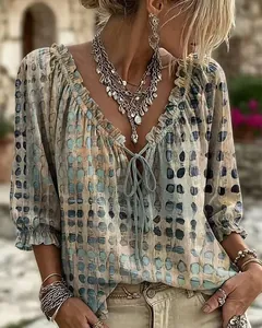 Detalle de camisa boho con lunares, escote en V con volantes y detalle de lazo