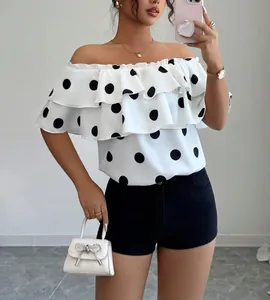 Front view of white ruffle off-the-shoulder blouse with bold black polka dots