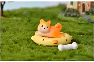 Dettaglio di una statuina di cane Shiba Inu su un galleggiante a forma di papera gialla.
