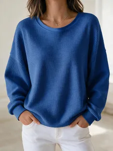 Close-up of blue waffle-knit texture on long-sleeved round neck pullover sweatshirt