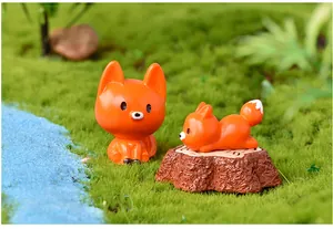 Primo piano di graziose figurine di volpe in resina arancione in un ambiente micro-paesaggio