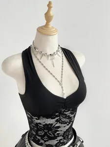Primo piano del top nero con pizzo e collane a croce in argento indossati su un manichino