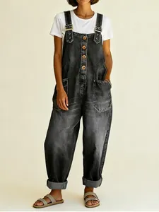 Detailed view of vintage washed black denim overalls with buckles and button front