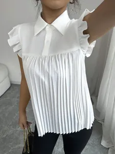 Dettaglio di una camicia bianca a pieghe con maniche corte, volant e colletto polo