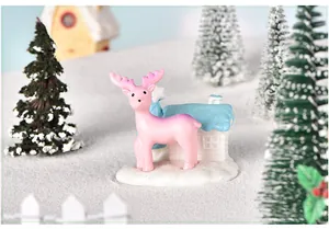 Gros plan d'une figurine de renne rose en résine dans une scène de paysage d'hiver