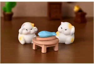 Détail en gros plan de mignonnes figurines miniatures de chats potelés en résine sculptée.