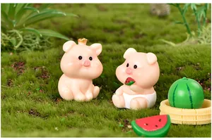 Vue détaillée de figurines de cochon en résine avec pastèque dans un paysage miniature