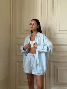 Elegante completo estivo due pezzi con camicia a maniche lunghe azzurra ampia e pantaloncini