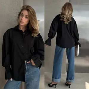 Front and back detail of a chic oversized black long-sleeved shirt with puff cuffs.