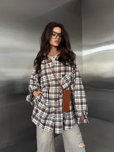 Oversized bruin geruit overhemd met lange mouwen gedragen door model in moderne setting