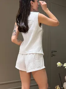 Vista posteriore di un completo casual da donna con gilet senza maniche e pantaloncini a righe