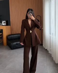 Detalle de elegante conjunto de blazer marrón entallado y pantalones anchos