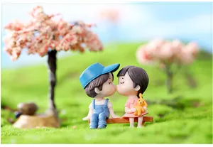 Detailweergave van miniatuur kussende paarbeeldjes op een bank voor DIY micro-landschap