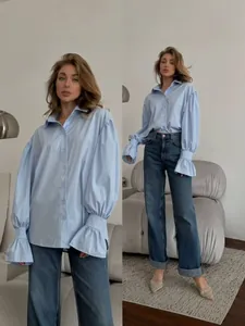Women's light blue oversized button-down shirt with elegant ruffled cuffs and balloon sleeves