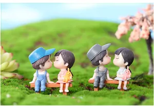 Twee paar schattige miniatuur koppelbeeldjes op bankjes voor DIY tuin decor