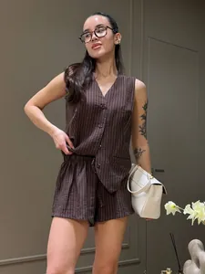 Modella alla moda che indossa un completo estivo marrone gessato con gilet e pantaloncini