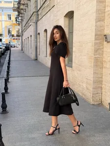 Elegant black waist-cinching A-line midi dress for a sophisticated chic summer look