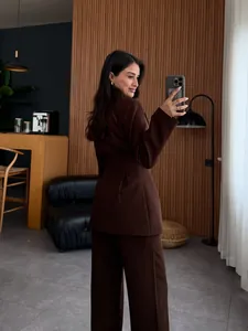 Elegante conjunto de blazer y pantalones marrones ajustados para mujer, ideal para oficina