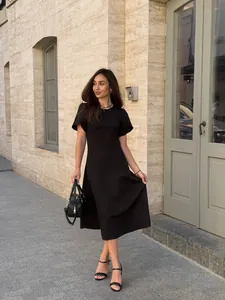 Full-length street style shot of an elegant black midi dress with flattering waistline