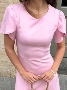 Detail view of a pink elegant summer dress featuring feminine flutter sleeves and a slim waistline