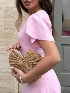 Close-up of a pink short-sleeved dress featuring elegant waist and ruffle sleeve details