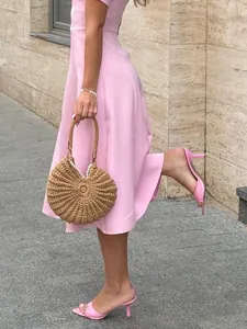 Close-up detail of a pink short-sleeved dress with a fitted waist and elegant A-line skirt
