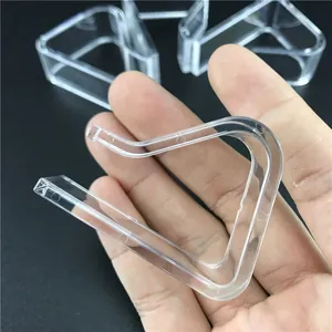 Gros plan d'un clip de nappe triangulaire en plastique transparent tenu dans une main