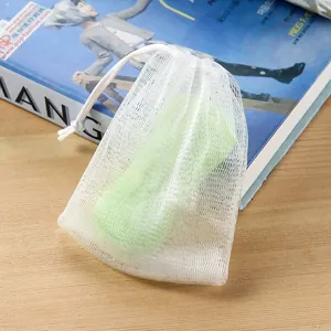 Detailopname van een dubbellaags wit zeepnetzakje met een groene zeep erin zichtbaar