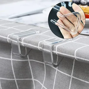 Vue détaillée de clips de nappe triangulaires transparents fixés sur une table à carreaux