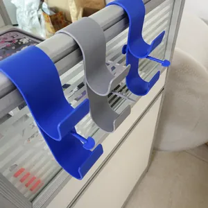 Close-up detail of durable blue and grey plastic swimming pool pipe holder hooks.