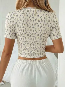 Rückansicht eines femininen floralen Slim-Fit-Crop-Tops mit zarter weißer Spitzenborte.