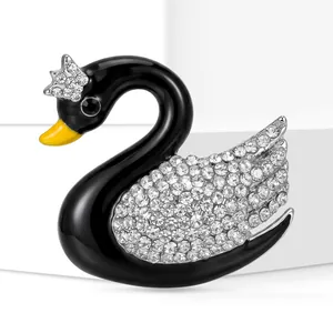 Dettaglio macro di elegante spilla cigno in smalto nero con strass scintillanti