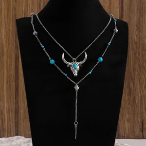 Dettaglio della collana bohémien a strati con perle turchesi e ciondolo a toro