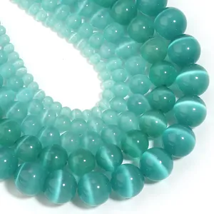 Close-up of teal cat's eye beads in various sizes for DIY jewelry making projects.