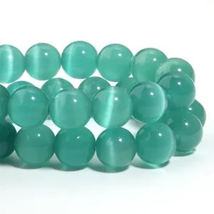 Macro view of polished teal cat-eye stone beads for handmade DIY jewelry making