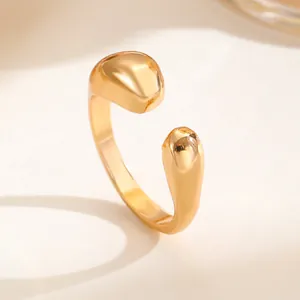 Nahaufnahme eines skulpturalen goldenen Wassertropfen-Rings mit glänzend polierter Oberfläche