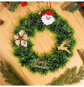 Vue détaillée d'une couronne de Noël festive verte avec renne doré et figurine du Père Noël