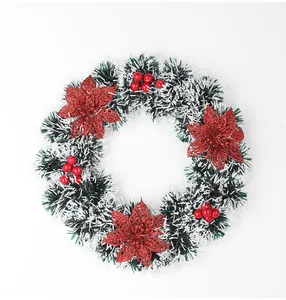 Vue détaillée d'une couronne de Noël en guirlande avec poinsettias rouges et baies