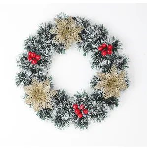 Vue détaillée d'une couronne de Noël artificielle avec fleurs dorées et baies rouges