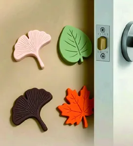 Detail van bladvormige siliconen deurstoppers in verschillende kleuren op een muur
