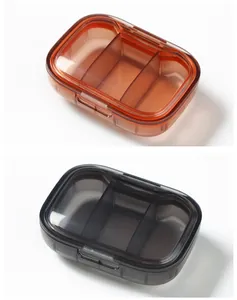 Portable translucent three-compartment pill storage boxes in amber and smoke grey colors
