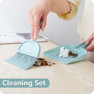 Mini bezem en stoffer set voor bureau reiniging op houten oppervlak.