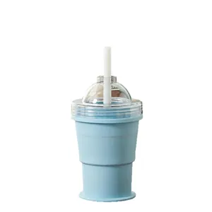 Side view of light blue silicone folding cup with clear lid and white straw.